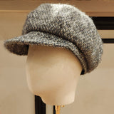 Textured gray cap on a mannequin head against a neutral background