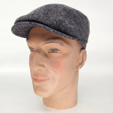 Mannequin head wearing a gray tweed cap on a white background