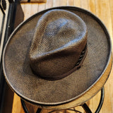 A Western inspired Shantung Straw fedora hat hand dyed in a warm grey brown wash featuring embossed leather and feathers
