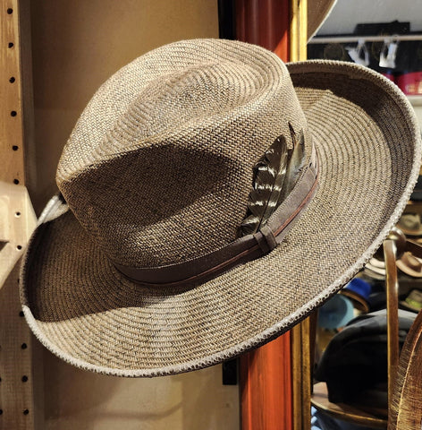 A Western inspired Shantung Straw fedora hat hand dyed in a warm grey brown wash featuring embossed leather and feathers