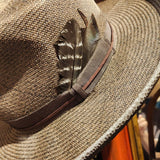 A Western inspired Shantung Straw fedora hat hand dyed in a warm grey brown wash featuring embossed leather and feathers