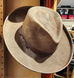 A Western inspired Shantung Straw fedora hat hand dyed in a warm grey brown wash featuring embossed leather and feathers